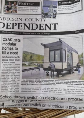Front page of the Addison County Independent newspaper featuring a story about modular tiny homes for adults with special needs, including a photo of a small accessible home with a wheelchair ramp.