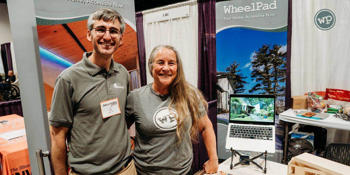 RJ and Julie stand together in front of their booth at the 2024 Abilities Expo, attending as part of the Remarkable Accelerator US Cohort.